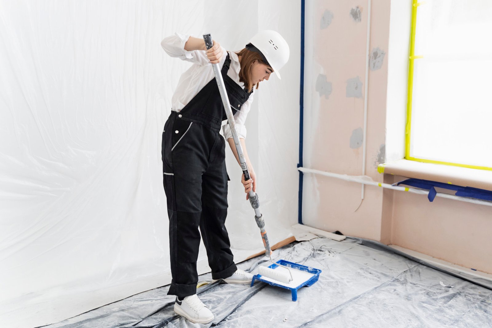 young woman painting house wall full shot scaled